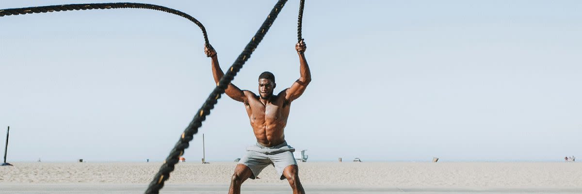 man op het strand met ropes